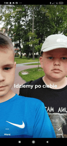 two boys are standing next to each other in a park with the words idziemy po ciebie on the bottom