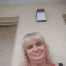 a woman is standing in front of a wall with a light on it .