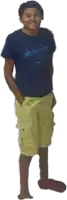 a young boy wearing a blue shirt and yellow shorts is standing with his hands in his pockets