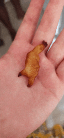 a person is holding a piece of food that looks like a bear