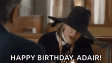 a woman in a hat is sitting next to a man in a church and says `` happy birthday , adair ! ''