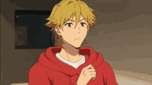 a young man with blonde hair and a red hoodie