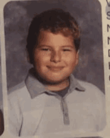 a young boy is smiling in a school photo .