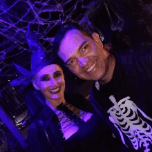 a man wearing a skeleton shirt and a woman in a witch costume