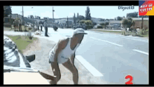 a man in a white tank top is kneeling down on the side of the road in front of a sign that says best of cultes