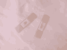 two bandages are laying on a white cloth on a bed .