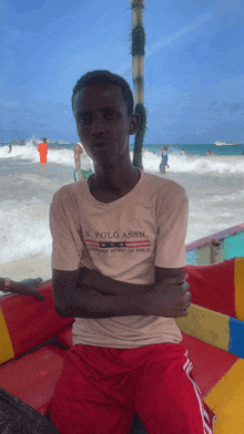 a young man wearing a us polo assn shirt sits on a boat