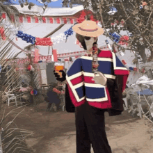 a man in a red white and blue poncho holds a glass of orange juice