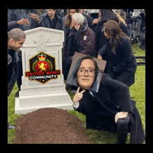 a woman kneeling in front of a grave with british army community written on it