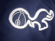 a blue shirt with a white embroidery of a basketball