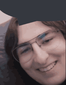 a close up of a person 's face with glasses and smiling