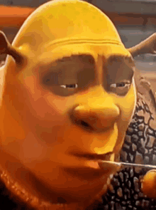 shrek from shrek is eating a piece of cheese with a straw .