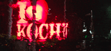 a red sign that says " no koch " is lit up at night