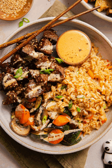 a close up of a plate of food with chopsticks