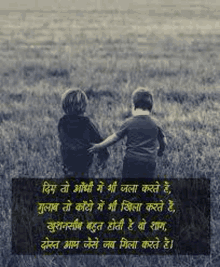 two children are standing next to each other in a grassy field holding hands .