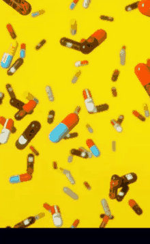 a bunch of pills are falling on a yellow surface