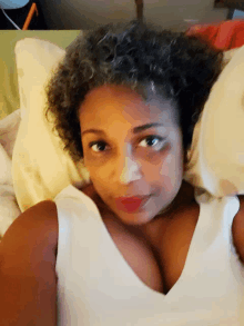 a woman laying on a bed with a white shirt on