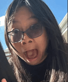 a woman wearing sunglasses is making a funny face with her mouth open