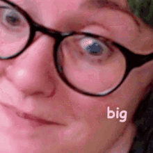 a close up of a woman 's face with glasses and the word big on her face