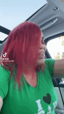 a woman with red hair is sitting in a car .