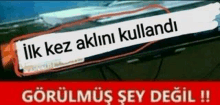 a picture of a car windshield with a sign that says ilk kez aklini kullandi .