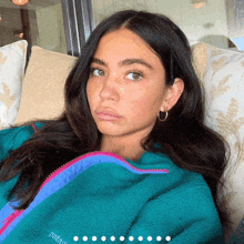 a woman wearing a green patagonia jacket looks at the camera