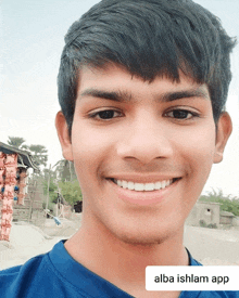 a young man is smiling in front of a sign that says alba ishlam app on it