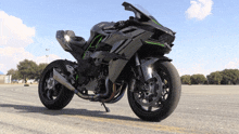 a kawasaki motorcycle is parked in a parking lot with trees in the background