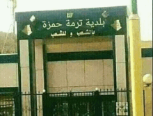 a building with arabic writing on it and a fence around it .