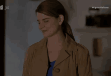 a woman in a trench coat with the hashtag agriesmelisses on the screen