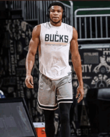 a basketball player wearing a white tank top that says bucks on it