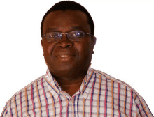 a man wearing glasses and a plaid shirt is smiling for the camera