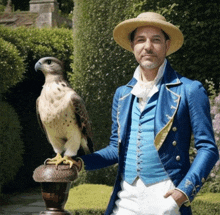 a man in a blue jacket is holding a bird