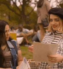 a woman wearing a black beret is holding a piece of paper that says ' i 'm sorry ' on it