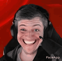 a man wearing headphones and a microphone is smiling with faceapp written on the bottom right