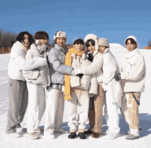 a group of people standing in the snow with one wearing a hat that says e