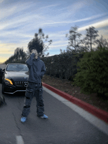 a man standing in front of a mercedes car