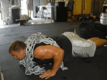 a man is doing push ups with chains around him .