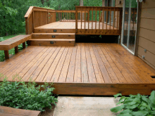 a wooden deck with stairs and a bench on it