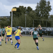 a group of female soccer players are playing a game and one player has the number 30 on her jersey