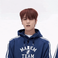 a young man wearing a blue maikm team sweatshirt