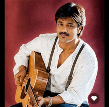 a man with a mustache is holding a guitar in front of a red background