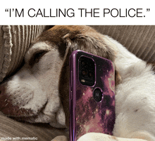 a dog laying on a couch next to a motorola phone that says i 'm calling the police