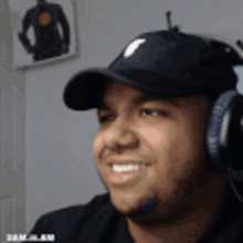 a man wearing headphones and a hat is smiling for the camera