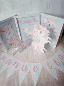 a banner that says " manuela 1 ano " sits on a wooden table