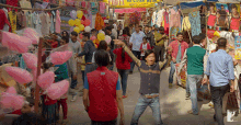 a man in a red vest is dancing in front of a sign that says ' jyoti western wear '