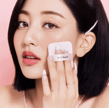 a woman is applying a milk touch cushion to her face