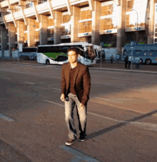 a man in a brown jacket stands on a street in front of a building with a sign that says pi