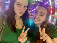 two girls are giving a peace sign in front of an arcade machine that says 18630