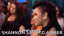 a woman with a braided mohawk and earrings is standing in front of a crowd and says shannon says to amber